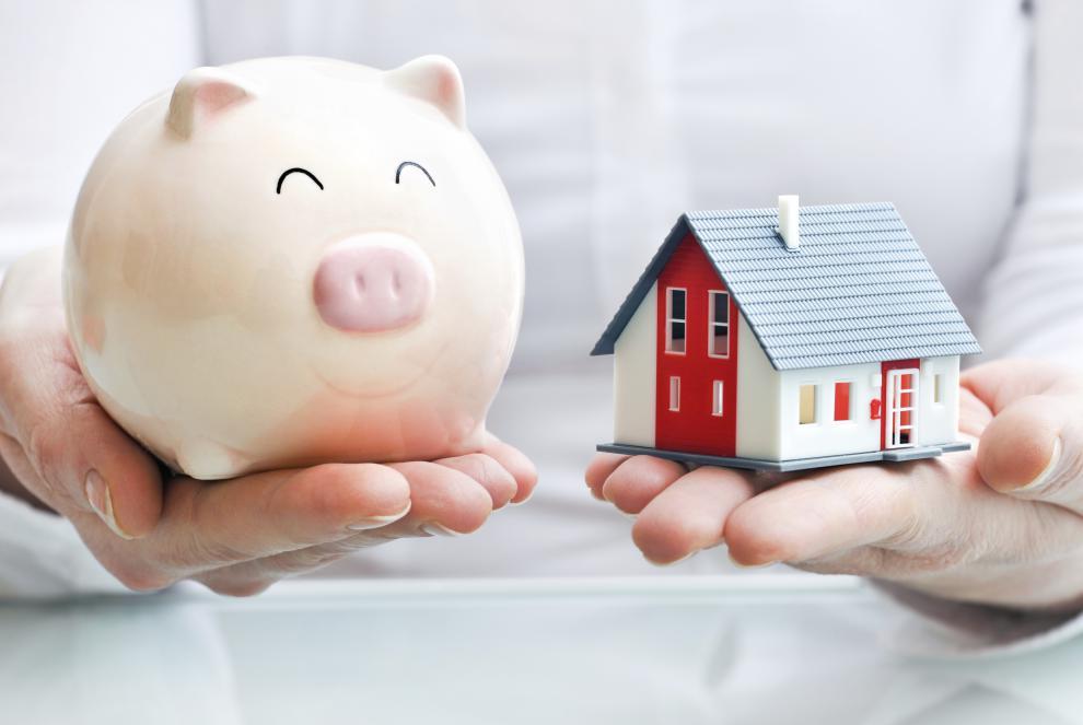 house and a piggy bank in hands